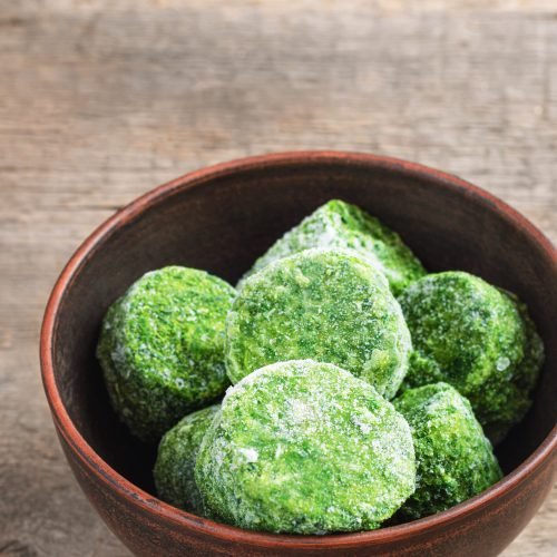 Frozen spinach on wooden background